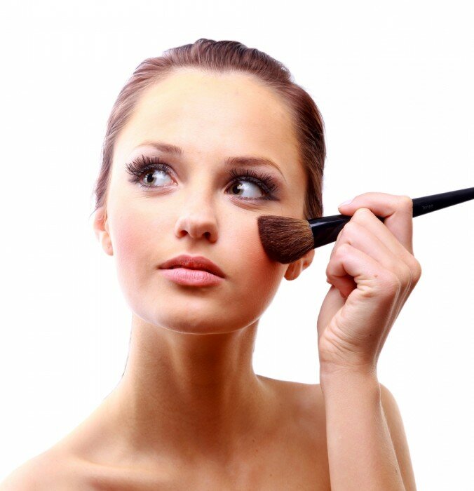 Woman applying foundation makeup.